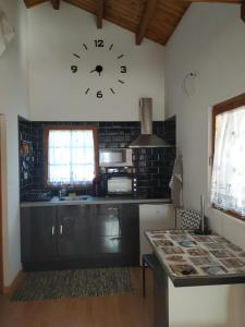 una cocina con un reloj grande en la pared en La casa del estanque en Olocau del Rey