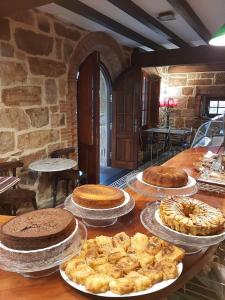 una mesa con varios pasteles y pasteles encima en Posada El Hidalgo, en Valdecilla