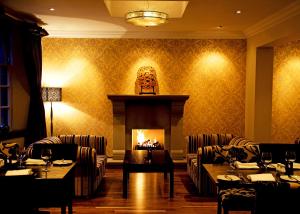 a dining room with couches and a fire place at The Popinjay Hotel in Larkhall