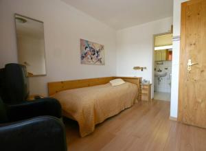 una camera da letto con un letto e un bagno di Hotel Pöstli a Maloja