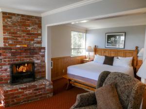 Carmel Fireplace Inn في كرمل: غرفة نوم بسرير ومدفأة