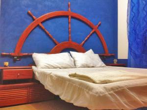 a bedroom with a bed with a large wooden headboard at B&B Wild Sardinia in Domusnovas