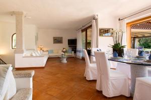 un soggiorno con tavolo e sedie bianche di Villa Smeralda Punta Lada Porto Rotondo a Porto Rotondo