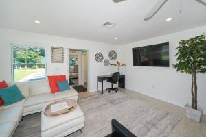 een woonkamer met een witte bank en een tafel bij Modern & Fresh - Less than 3 miles to the Beach! in Sarasota