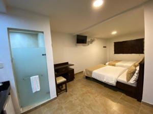 um quarto com uma cama e uma porta de vidro deslizante em Casa Hotel Las Orquideas em Circasia