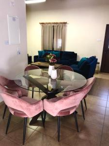 a living room with a glass table and pink chairs at Pramateftis House in Agros