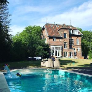 a large house with a swimming pool in front of it at B&B Villa Anna, Venlo in Venlo