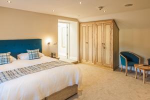 1 dormitorio con 1 cama grande, mesa y sillas en Gwesty'r Emlyn Hotel, en Newcastle Emlyn