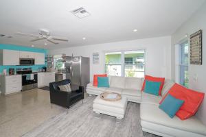 een woonkamer met een witte bank en een keuken bij Modern & Fresh - Less than 3 miles to the Beach! in Sarasota