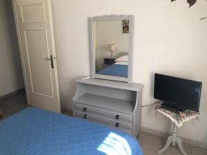 a bedroom with a bed and a mirror and a television at Margarita Studios in Parikia