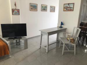 a living room with a table and a television at Margarita Studios in Parikia