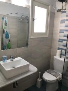 a bathroom with a sink and a toilet and a window at Margarita Studios in Parikia