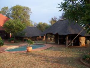 une cabane avec une piscine en face d'une cour dans l'établissement Boschfontein Guest Farm, à Thabazimbi