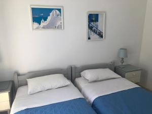 a bedroom with two beds and two pictures on the wall at Margarita Studios in Parikia