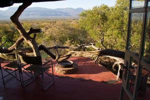 une chaise sur une terrasse couverte avec vue sur le désert dans l'établissement Boschfontein Guest Farm, à Thabazimbi