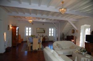 a living room with white furniture and a dining room at Mas de la Garrigue in Les Vans