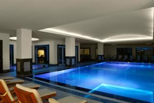 a large swimming pool in a hotel with chairs at Xanadu Island in Akyarlar