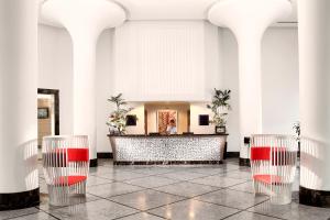 a lobby with three red chairs and a counter at Xanadu Island in Akyarlar