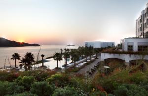 a sunset over a beach with palm trees and buildings at Xanadu Island in Akyarlar