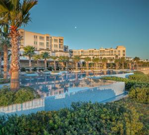 an aerial view of a resort pool with palm trees at Xanadu Island in Akyarlar