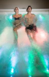two people sitting in a pool of water at Xanadu Island in Akyarlar