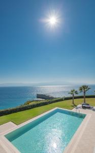 a swimming pool with the ocean in the background at Xanadu Island in Akyarlar