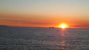 a sunset over the ocean with the sun setting at Margarita Studios in Parikia