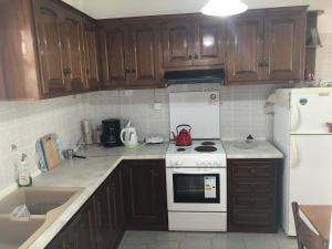 a kitchen with a white stove and a white refrigerator at Margarita Studios in Parikia