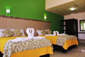 two swans are sitting on two beds in a room at Villa Victoria Pirámides in San Martín de las Pirámides