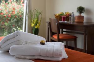 Ilalo Garden Hotel & Restaurant في كيتو: منشفة بيضاء عليها خاتم فوق السرير