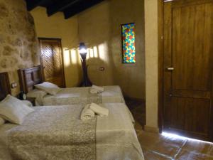 Zimmer mit 2 Betten und einem Buntglasfenster in der Unterkunft Casa Rural Castillo LA Iruela in La Iruela