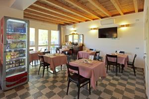 un restaurante con mesas, sillas y nevera en IL SOLE NEL MARE - Lido di Volano, en Comacchio