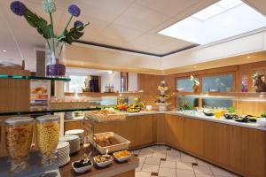 a large kitchen with a lot of food at Geographotel Paris-Roissy CDG Airport in Le Mesnil-Amelot