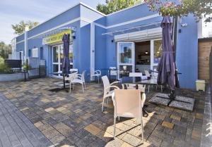 a blue building with white chairs and tables at IL SOLE NEL MARE - Lido di Volano in Comacchio