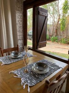 a table with two plates and wine glasses on it at Pousada Santa Vila in Serra do Cipo