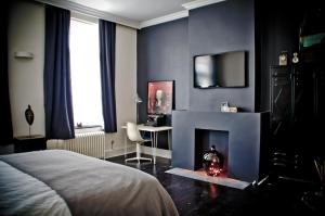 a bedroom with a bed and a desk and a fireplace at B&B House Ninety in Brussels