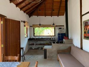 a living room with a couch and a kitchen at Pousada Santa Vila in Serra do Cipo