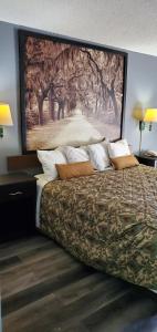 a bedroom with a bed with a large painting on the wall at Palmetto Inn in Estill