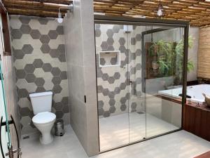 a bathroom with a shower and a toilet and a tub at Pousada Santa Vila in Serra do Cipo