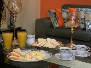 a table topped with plates of food and cups of coffee at Hotel Colibri in San Vicente de Cañete