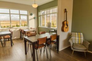 a dining room with a table and a guitar on the wall at Soti Lodge in Fljot