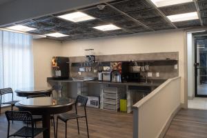 a kitchen with two tables and a counter with chairs at Hotel Chataura in Dearborn