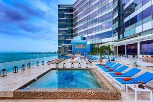 une piscine avec des chaises longues et un bâtiment dans l'établissement Hotel InterContinental Cartagena, an IHG Hotel, à Carthagène des Indes