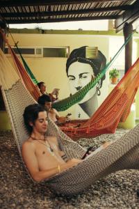 a group of naked men sitting in a hammock at Casa Losodeli & Coworking- Adults Only in Puerto Escondido