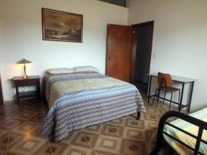 een slaapkamer met een bed, een tafel en een bureau bij Quito Eco Lodge Airport - B&B in Tababela
