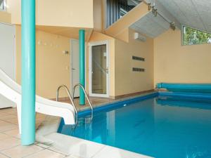 una gran piscina con una silla blanca al lado en Five-Bedroom Holiday home in Ebeltoft 4, en Ebeltoft