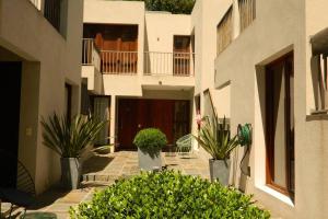 a courtyard of a building with potted plants at Patio del Bastion in Colonia del Sacramento