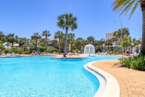 a swimming pool at a resort with palm trees at Sterling Shores V in Destin