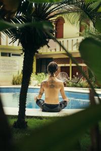 a man with a tattoo on his back sitting next to a pool at Casa Losodeli & Coworking- Adults Only in Puerto Escondido