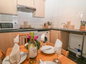 a kitchen with a table with a bottle of wine at Exchange Cottage in Tideswell